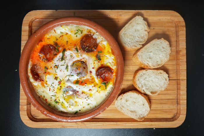 Provoleta gratinada con orégano y chorizo, servida con pan tostado